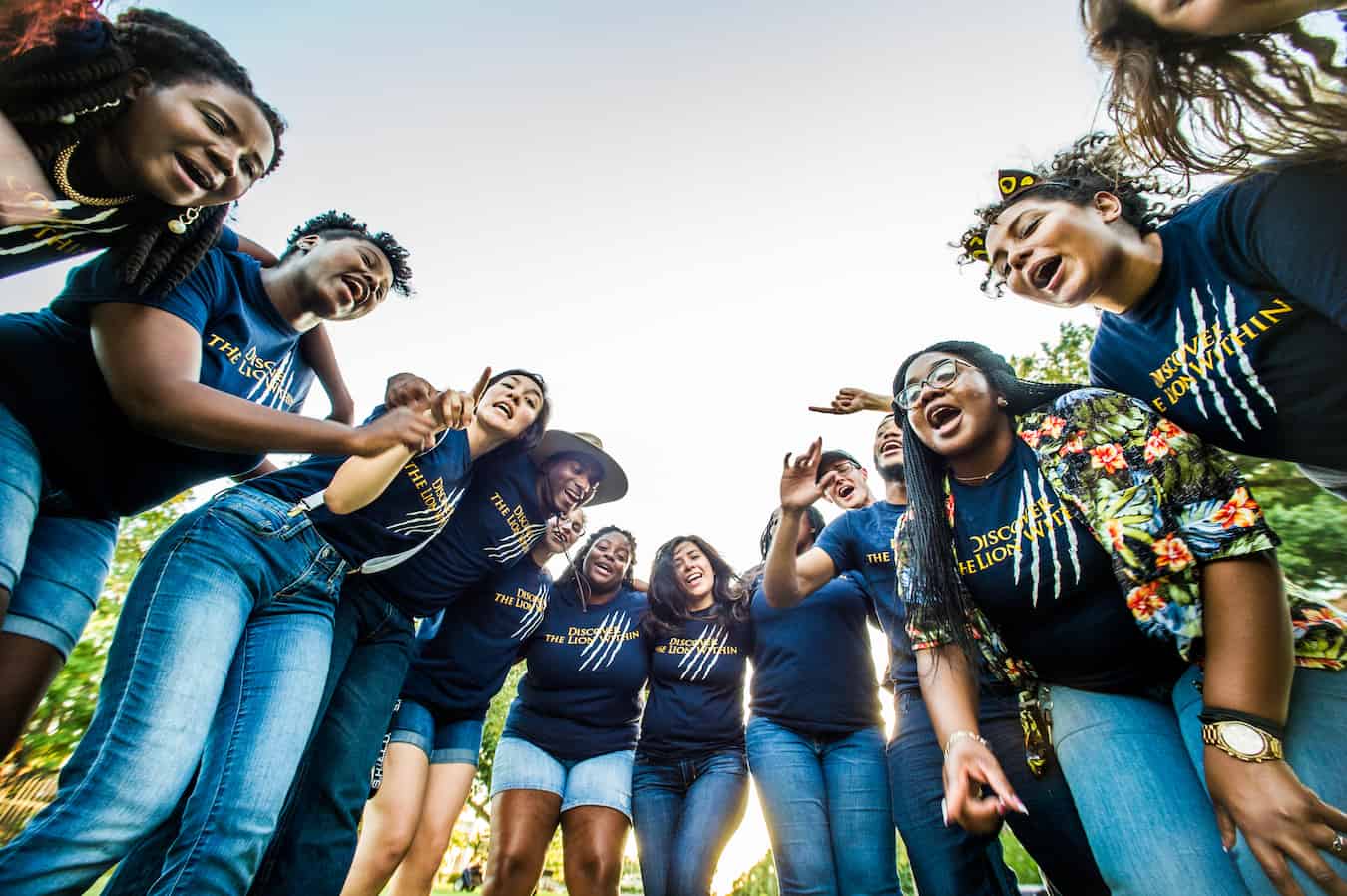 A group of student a round the camera saying something,