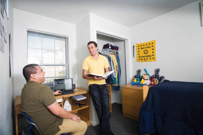 a man in a yellow shirt standing in a room.