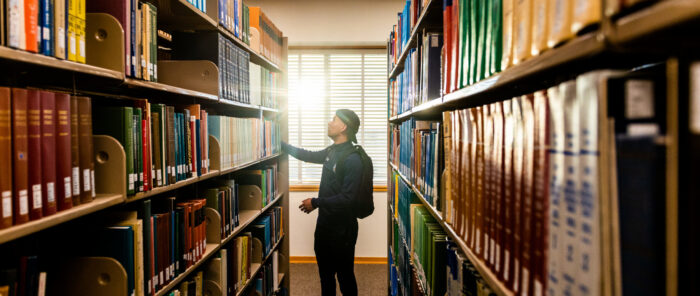 Student looking through books at the library.