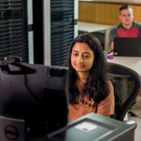 Computer science student looking at computer
