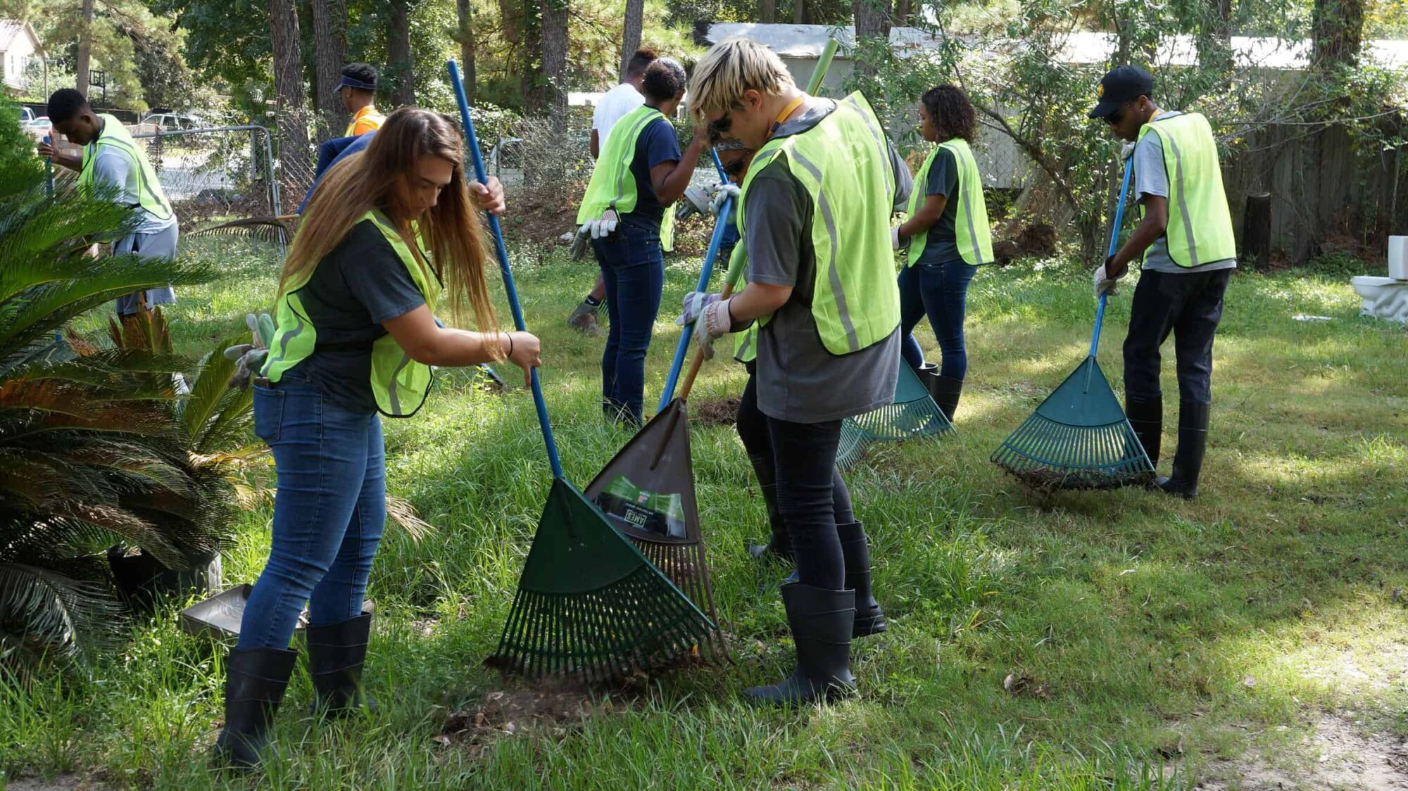 A group of students racking leaves.