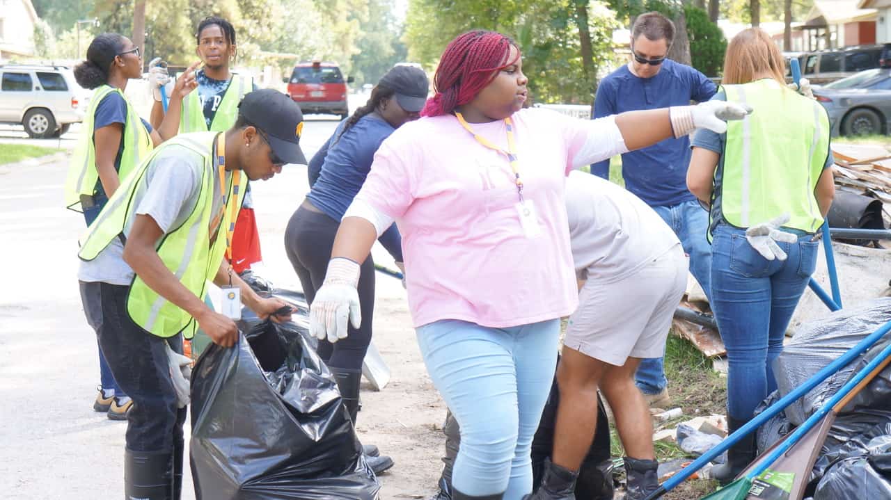 A group of individual working together to grab garbage.