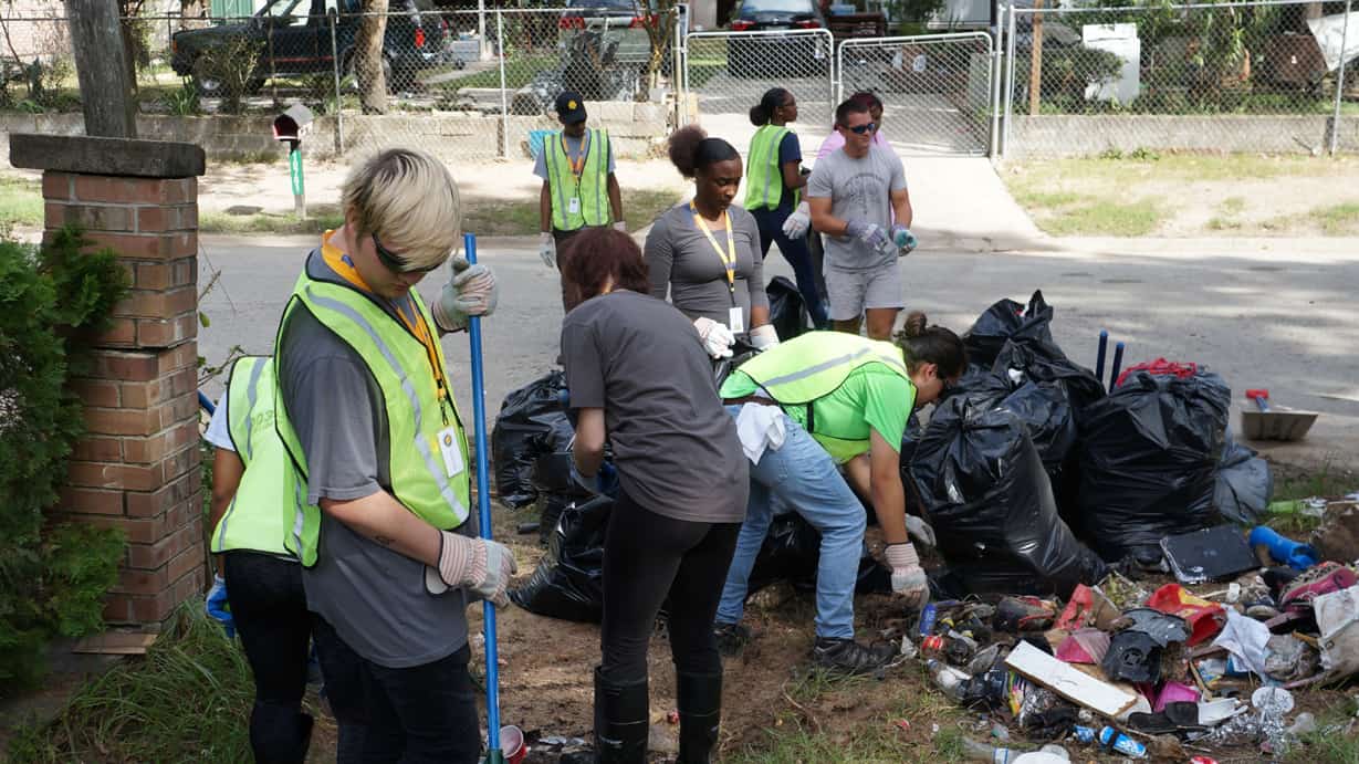 A group of students picking up garage from the ground.