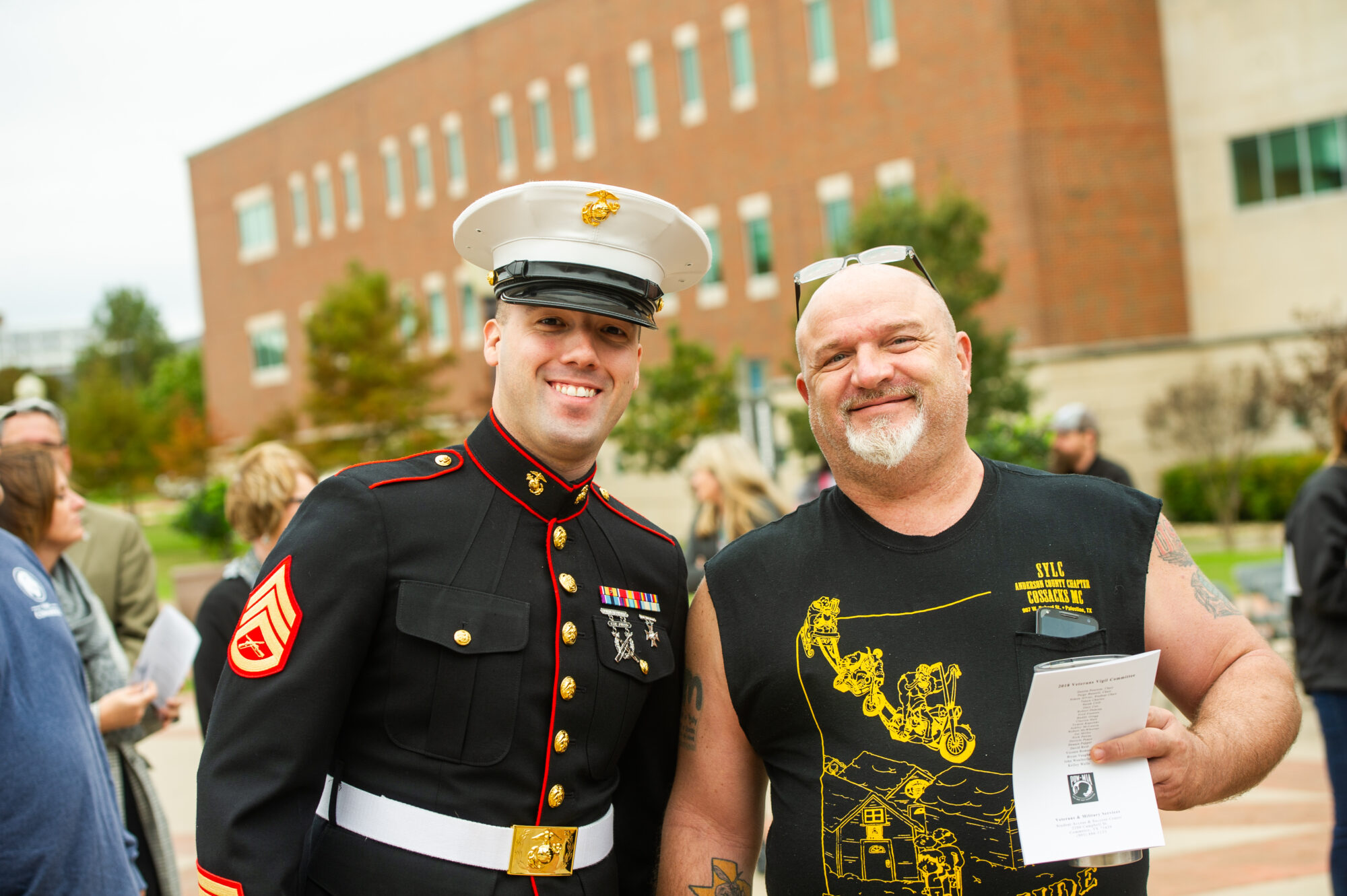Man in formal uniform posing for a picture with another person on the TAMUC campus.