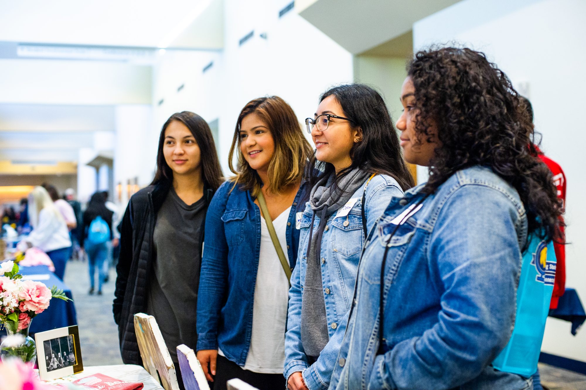 4 Hispanic students at a booth learning more about the university