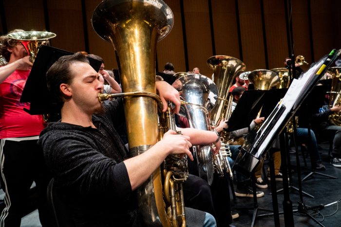 A male student playing the tuba.