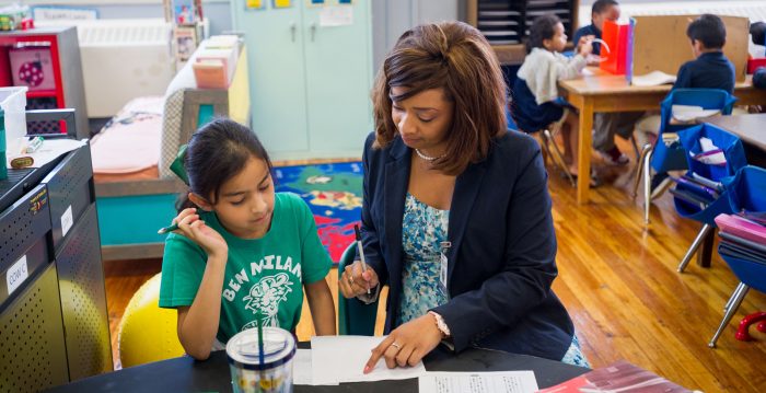 A student teacher helping a child with their school work.