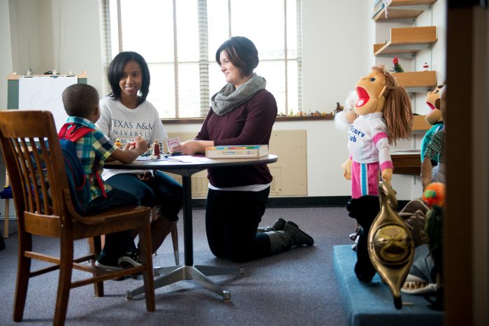 Two female students counseling an infant boy.