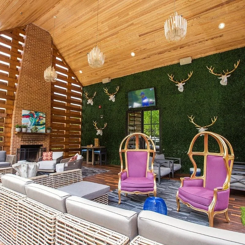 Inside a restaurant with pink chairs and fake green Turf
