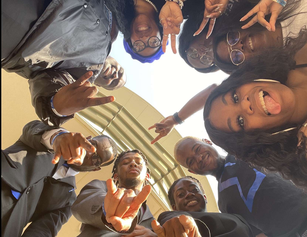 A group of students faces looking down at the camera.