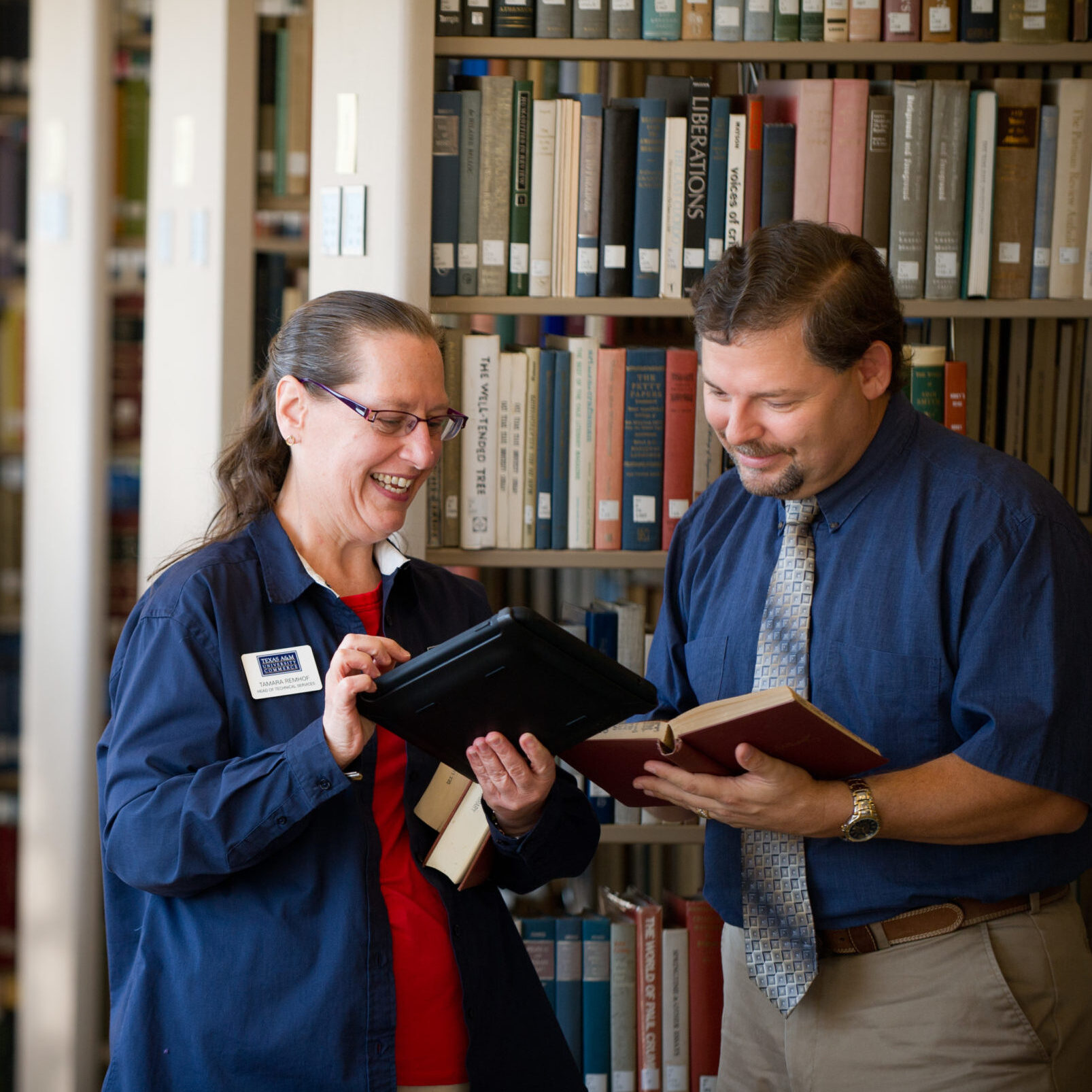 Two librarians standing in a library.