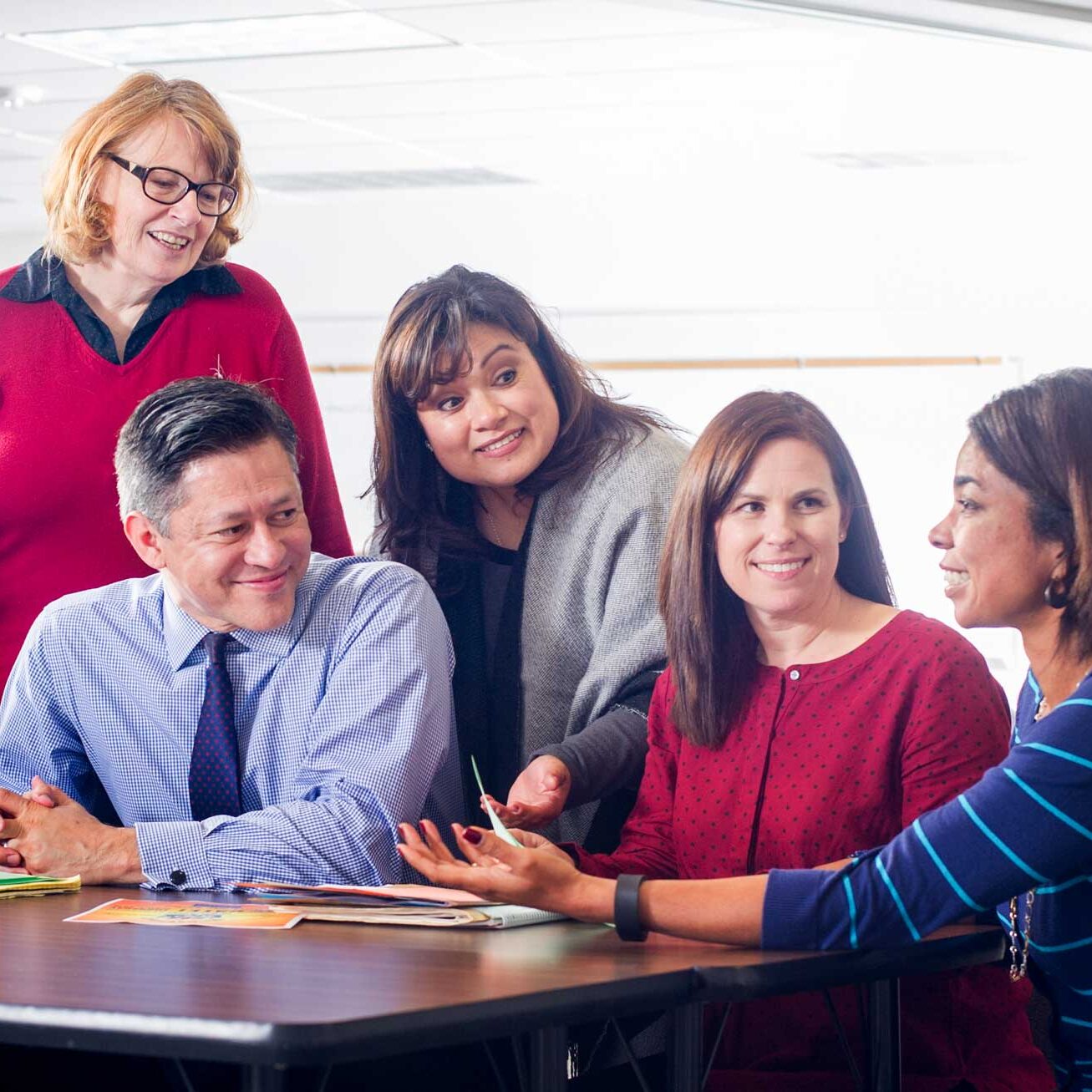 A group of instructors sitting at the table having a conversation.