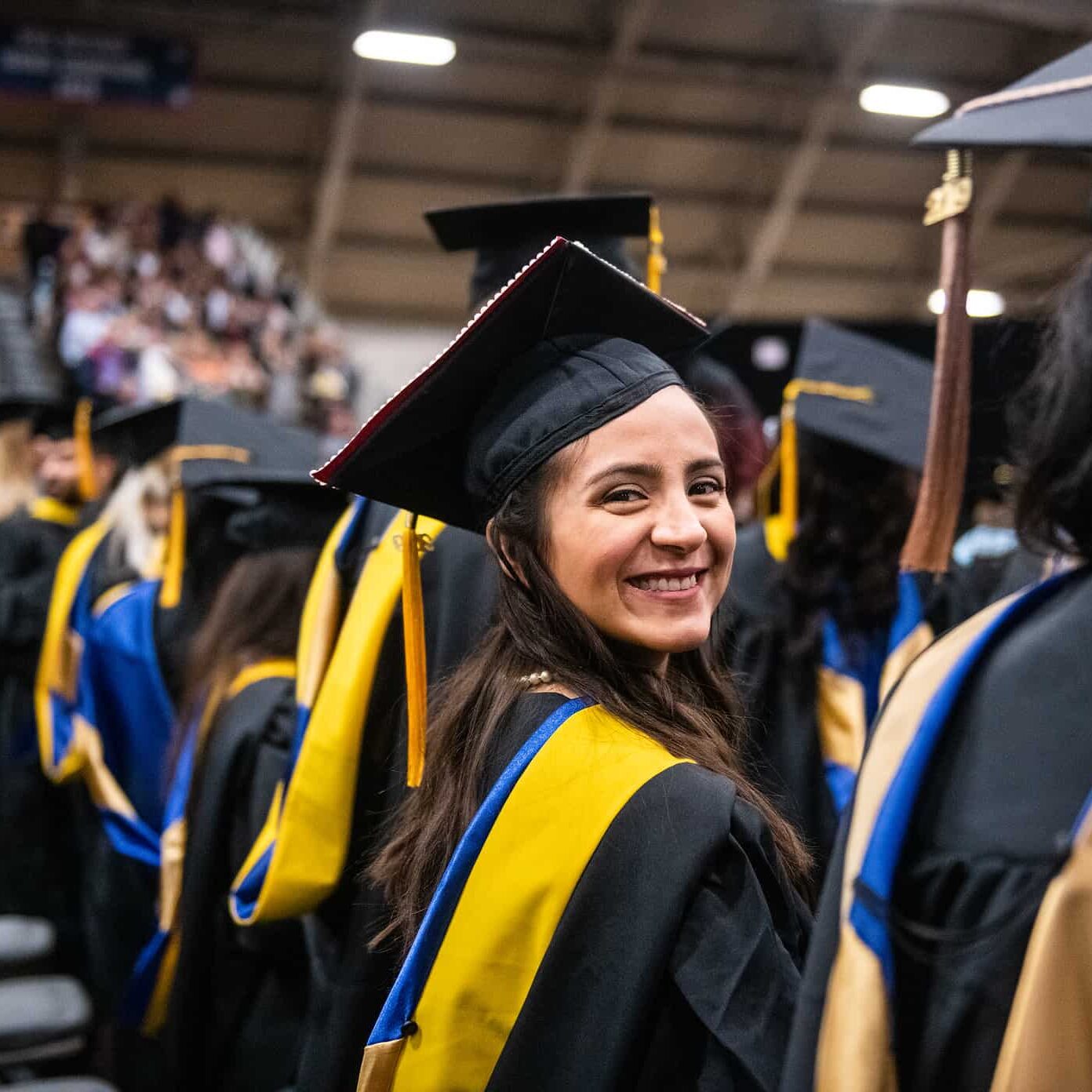 Graduate student smiling at the camera during graduation.