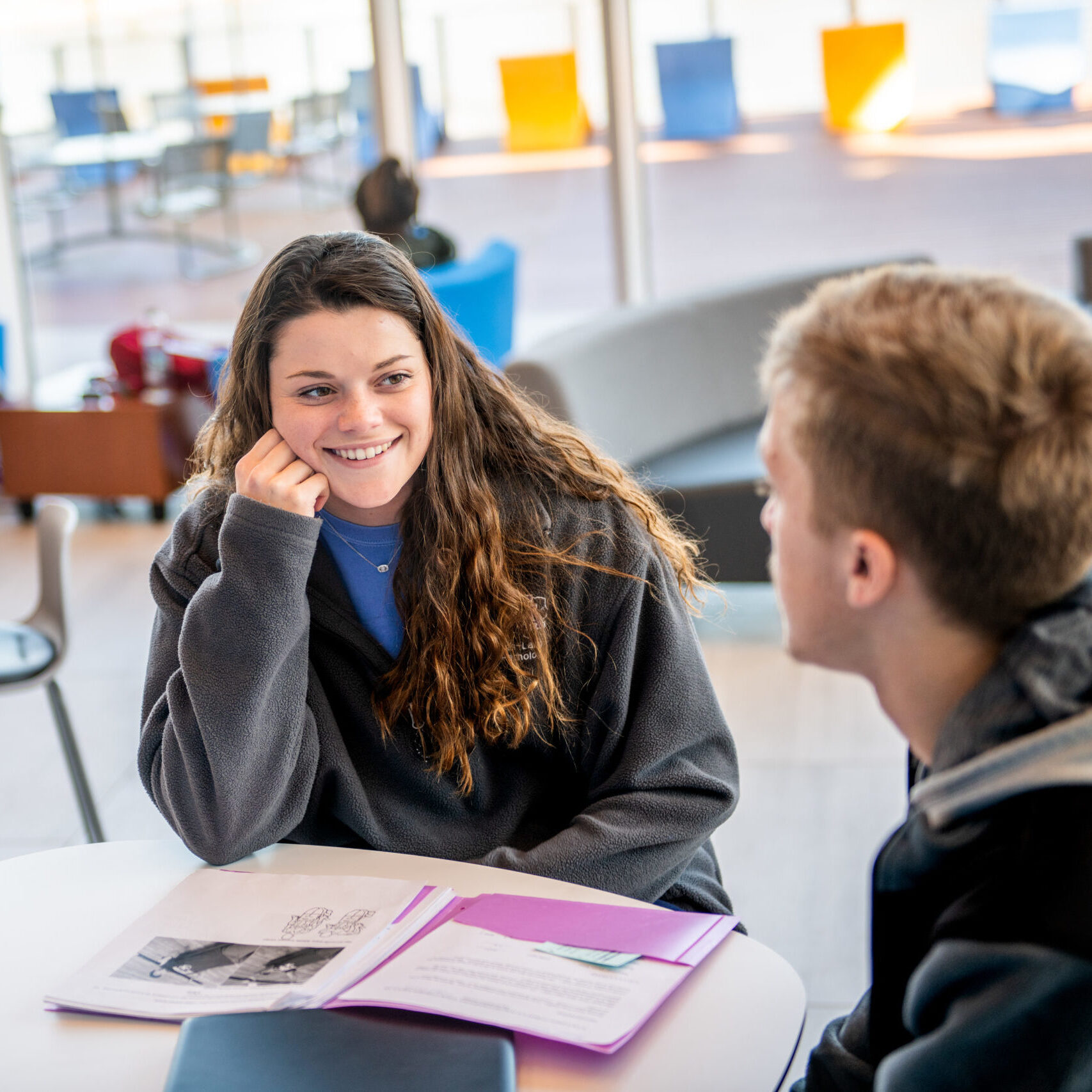 Young woman speaking with man in classroom environment