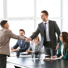 Human resources manager shaking hands with applicant after successful interview