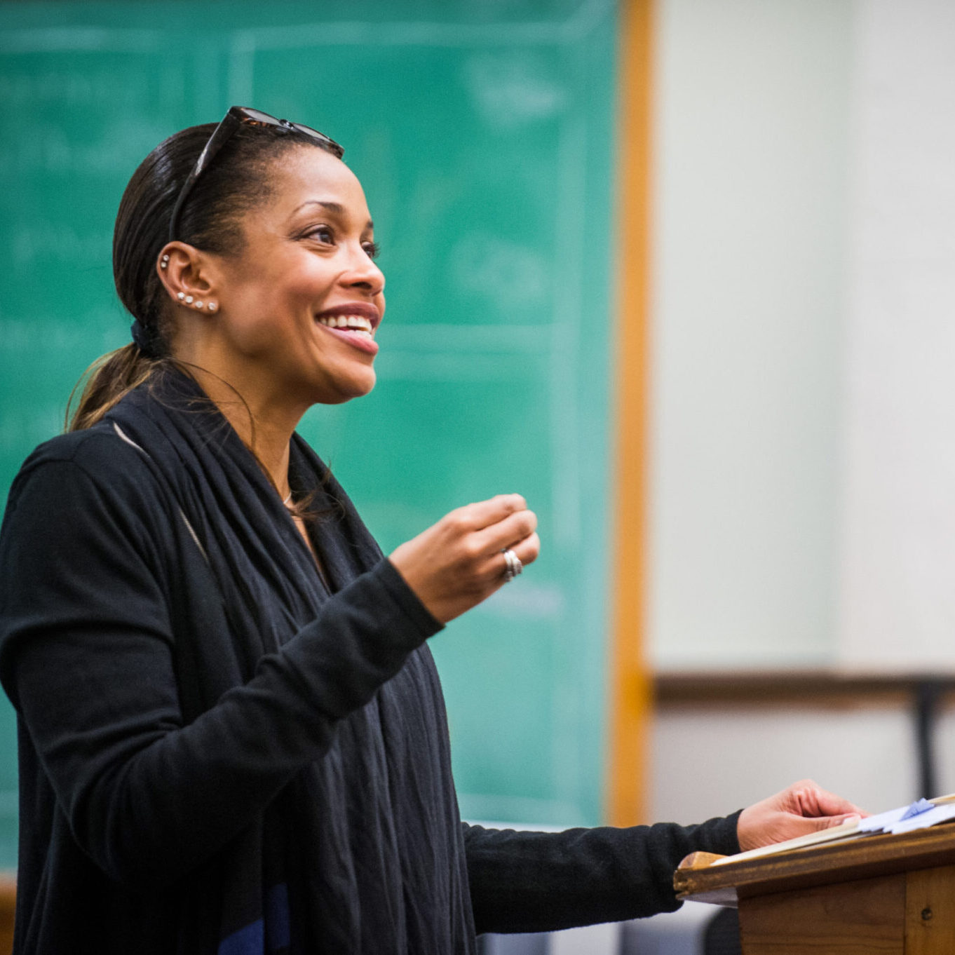 A female professor lecturing in a classroom.