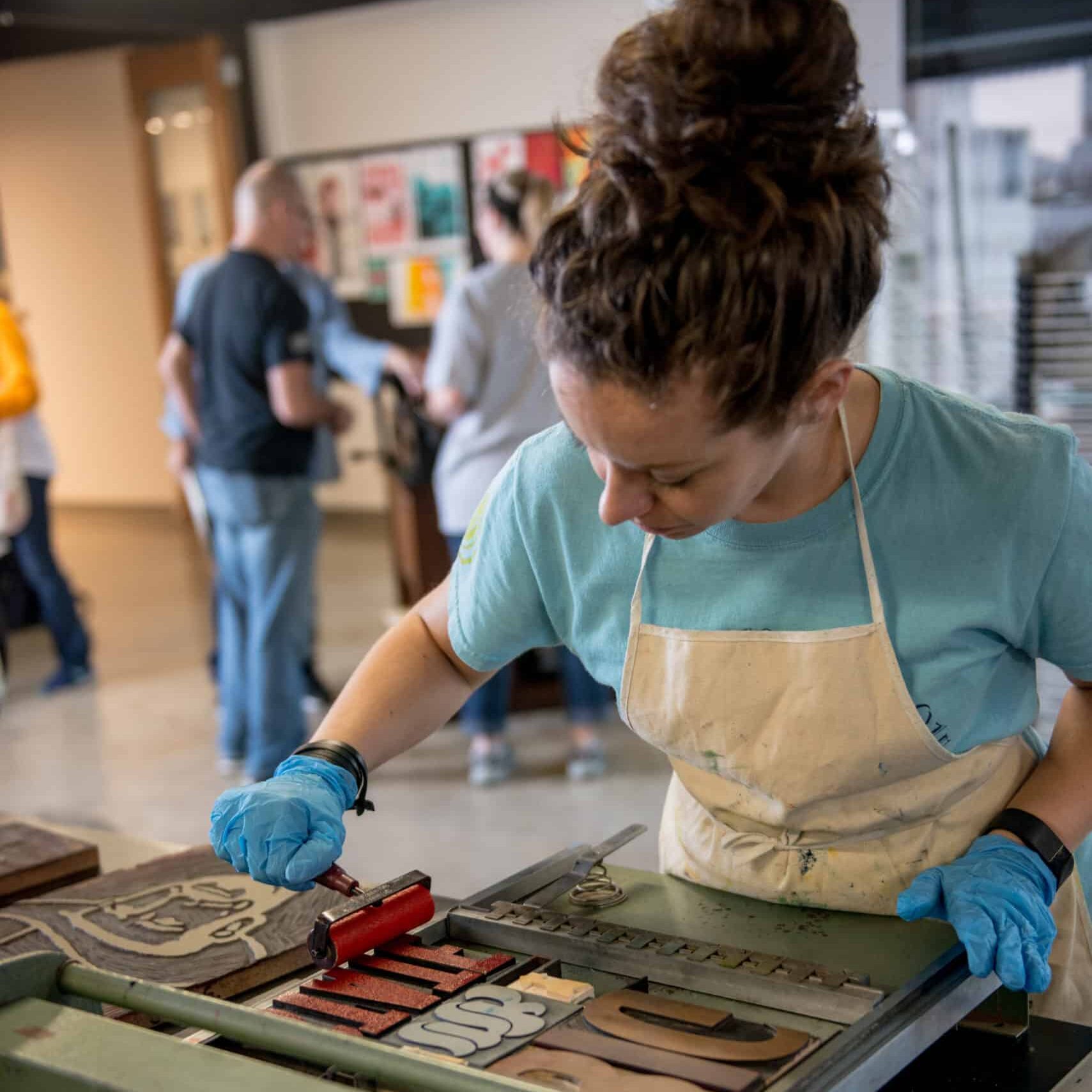 Student using a print press.