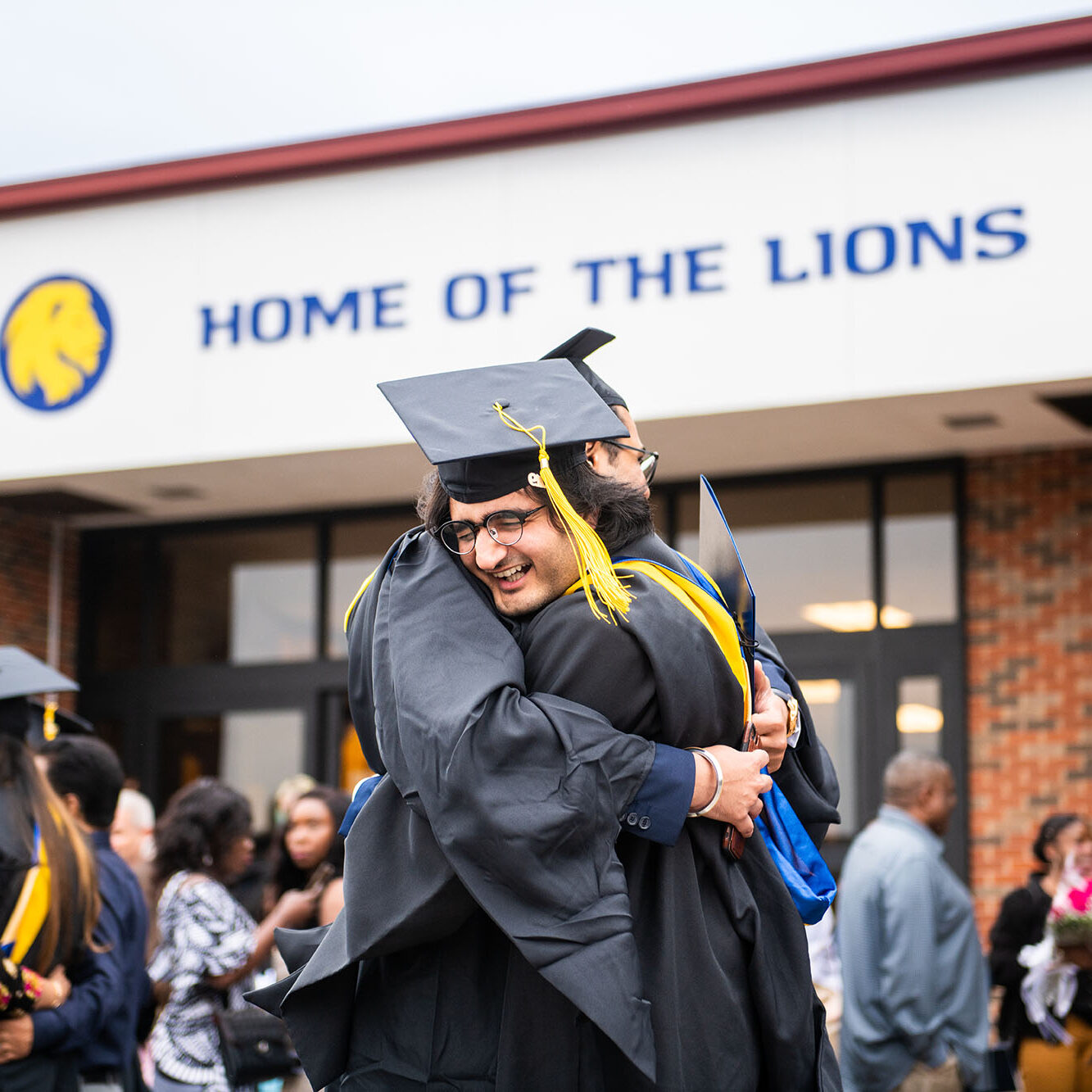 Two students hugging each other after graduation.
