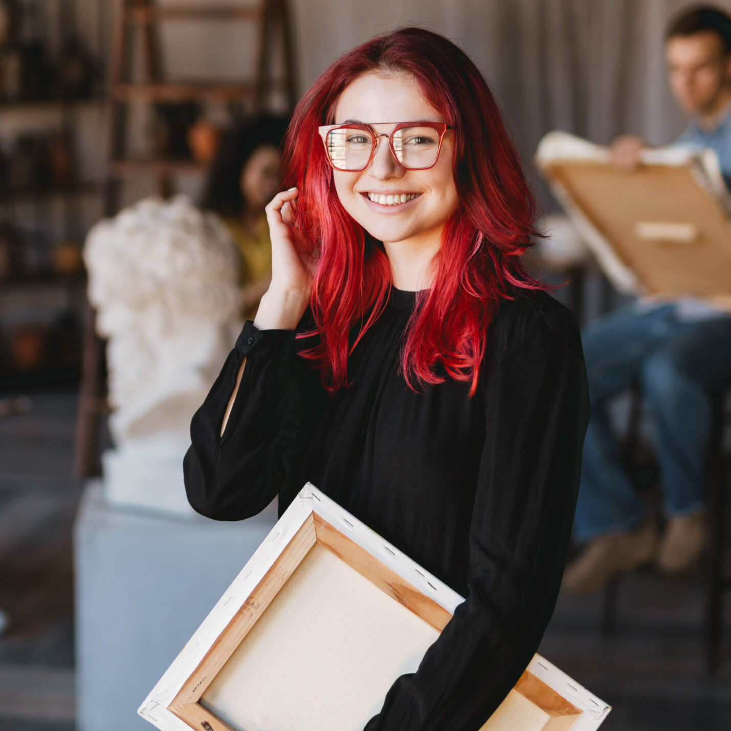 Young student woman smiling at camera during class in art school indoors