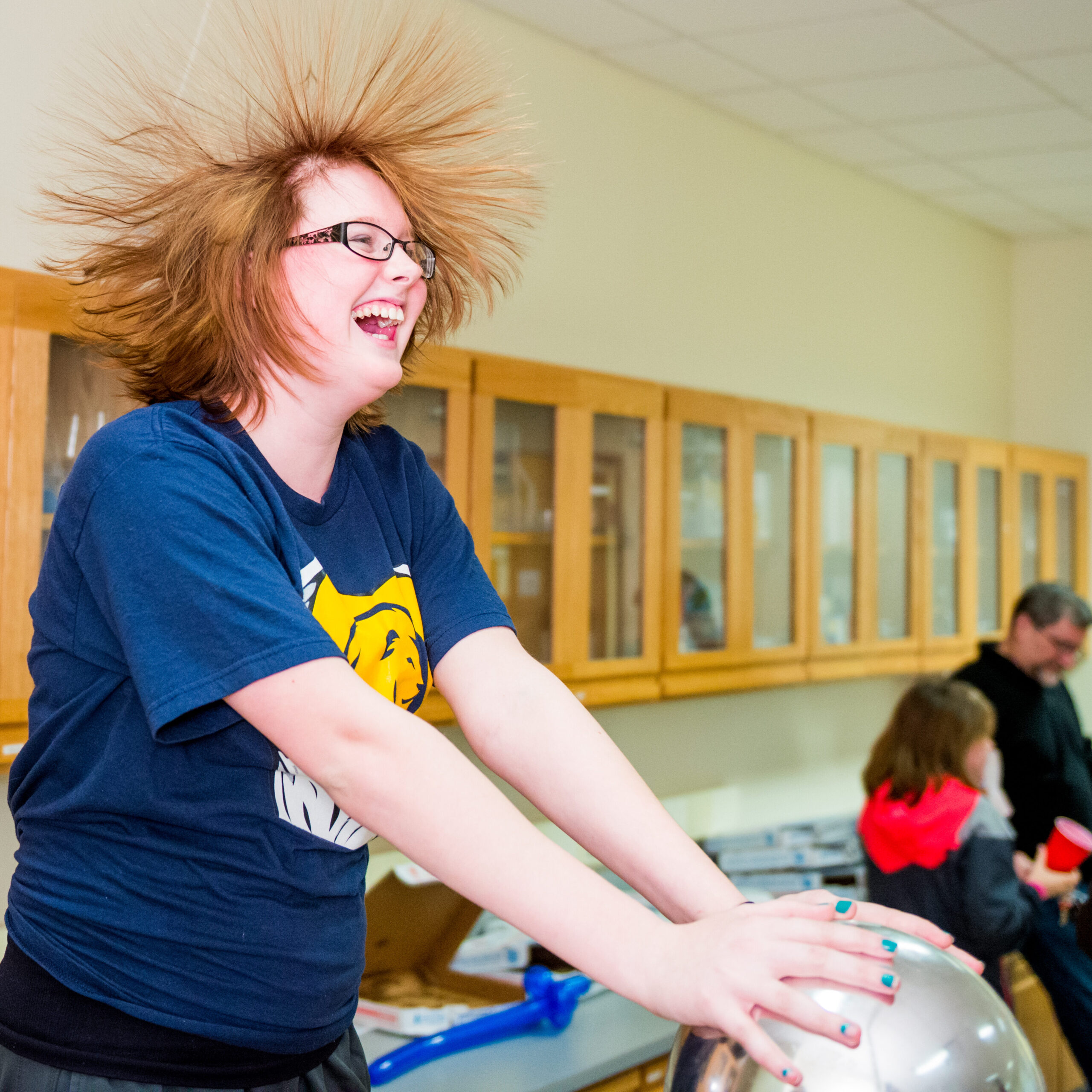 A woman demonstrates the effects of the Van de Graaff generator.