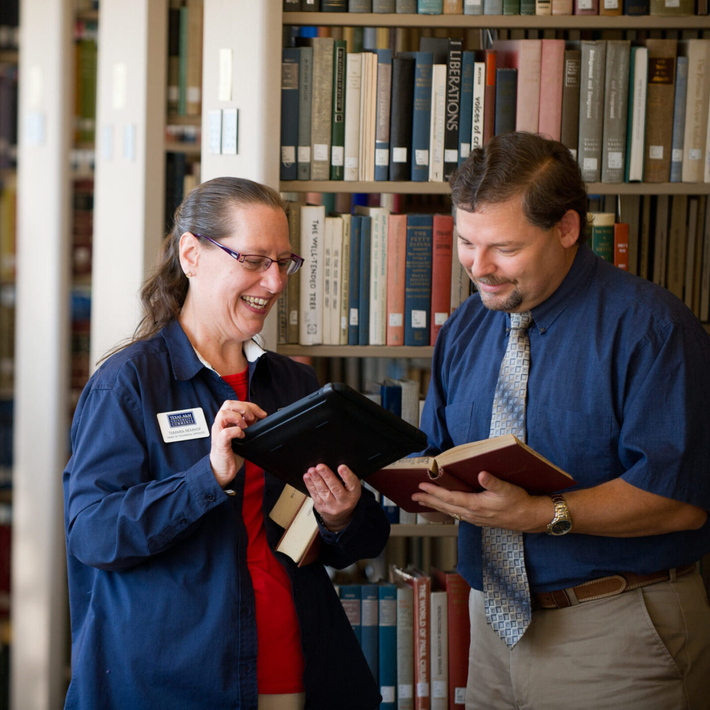 Two librarians standing in a library.