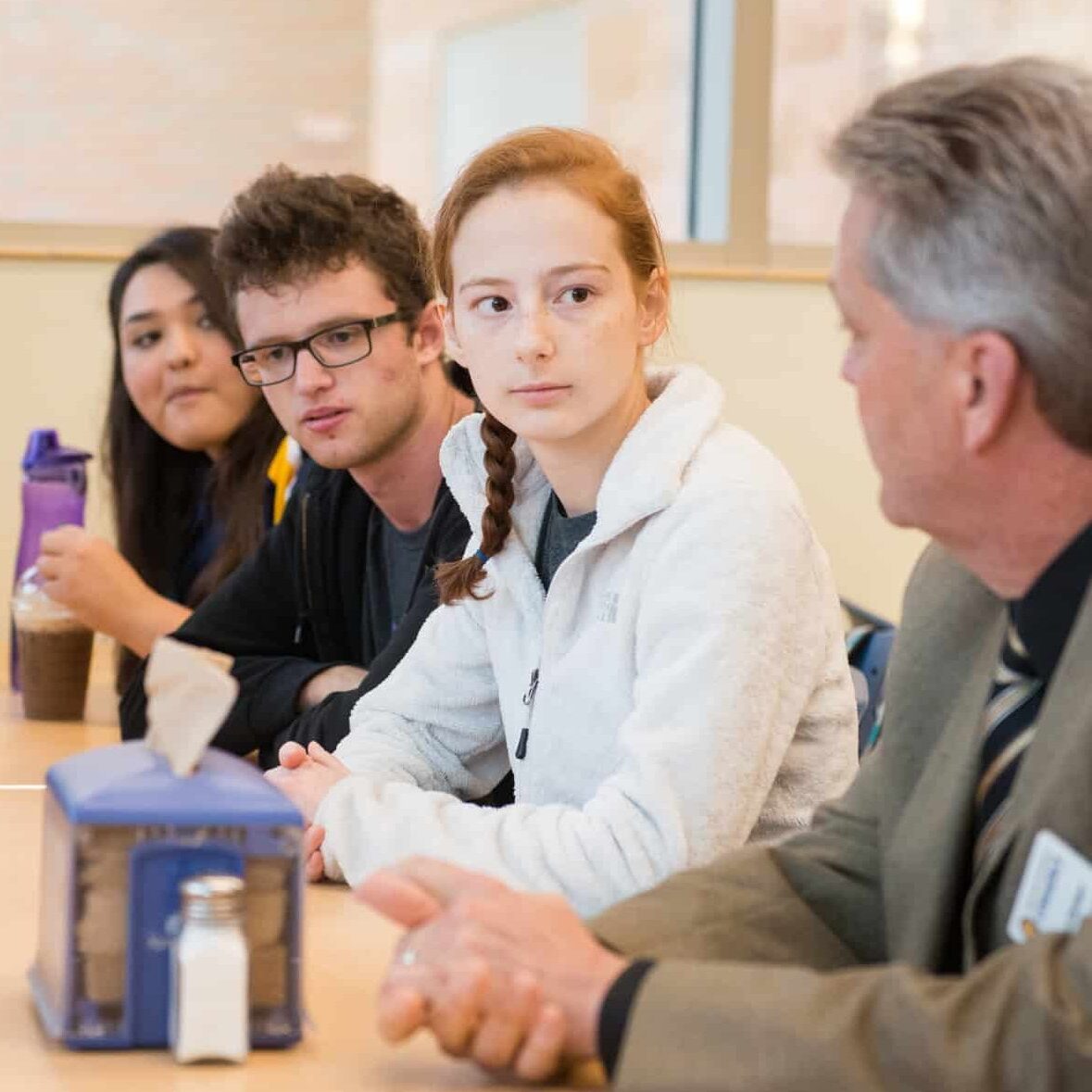 Students sitting with professor at table