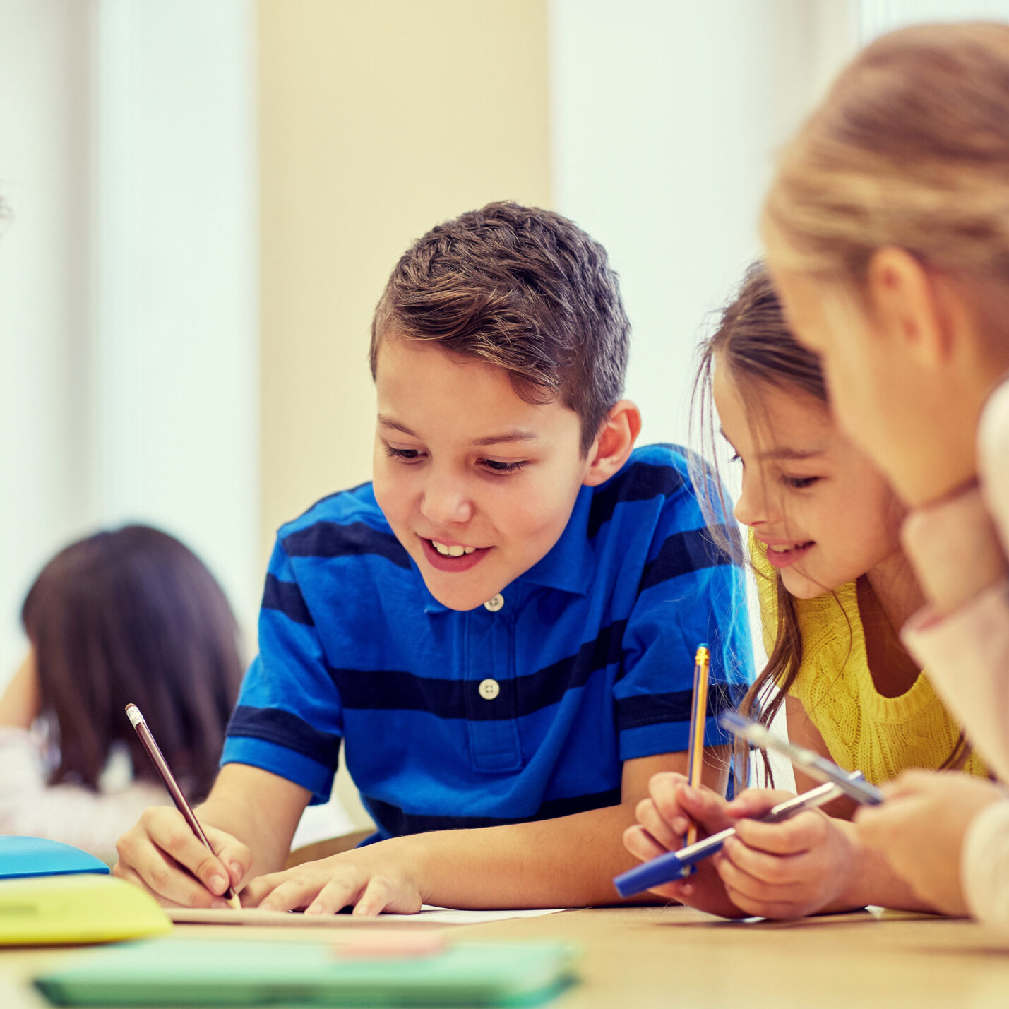 A student helping couple of students   with school work. 