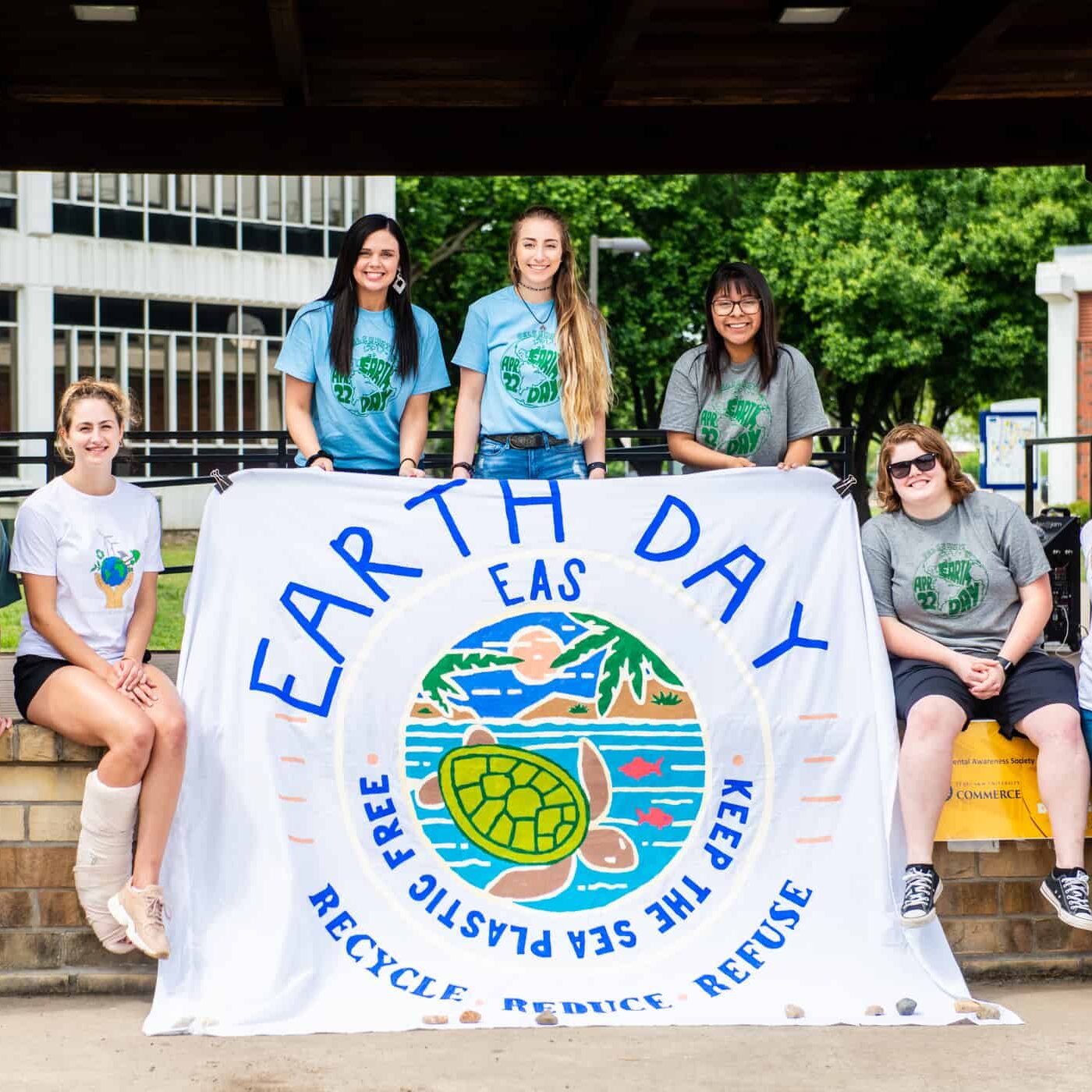 Environmental science students standing with poster