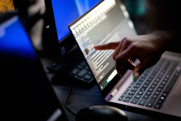 A student coding on a laptop.