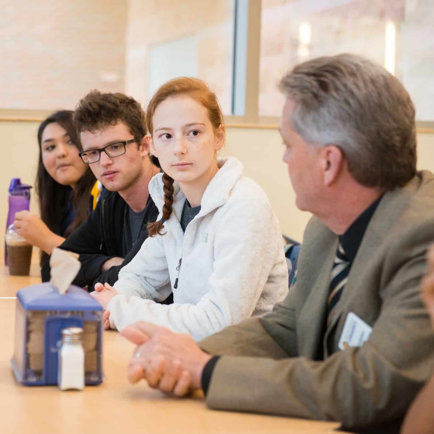 Students sitting with professor at table