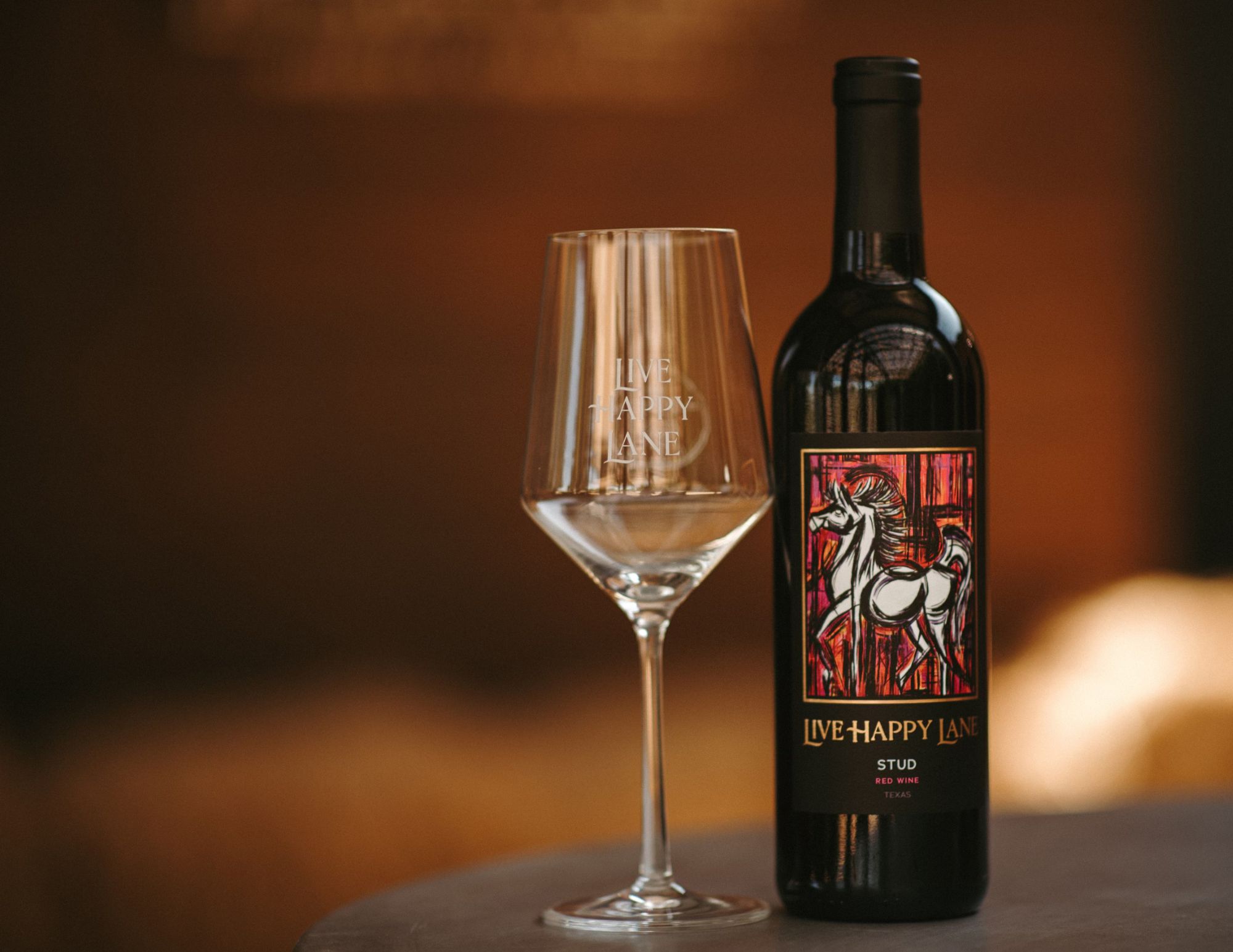 A bottle of wine with a wine glass beside it.