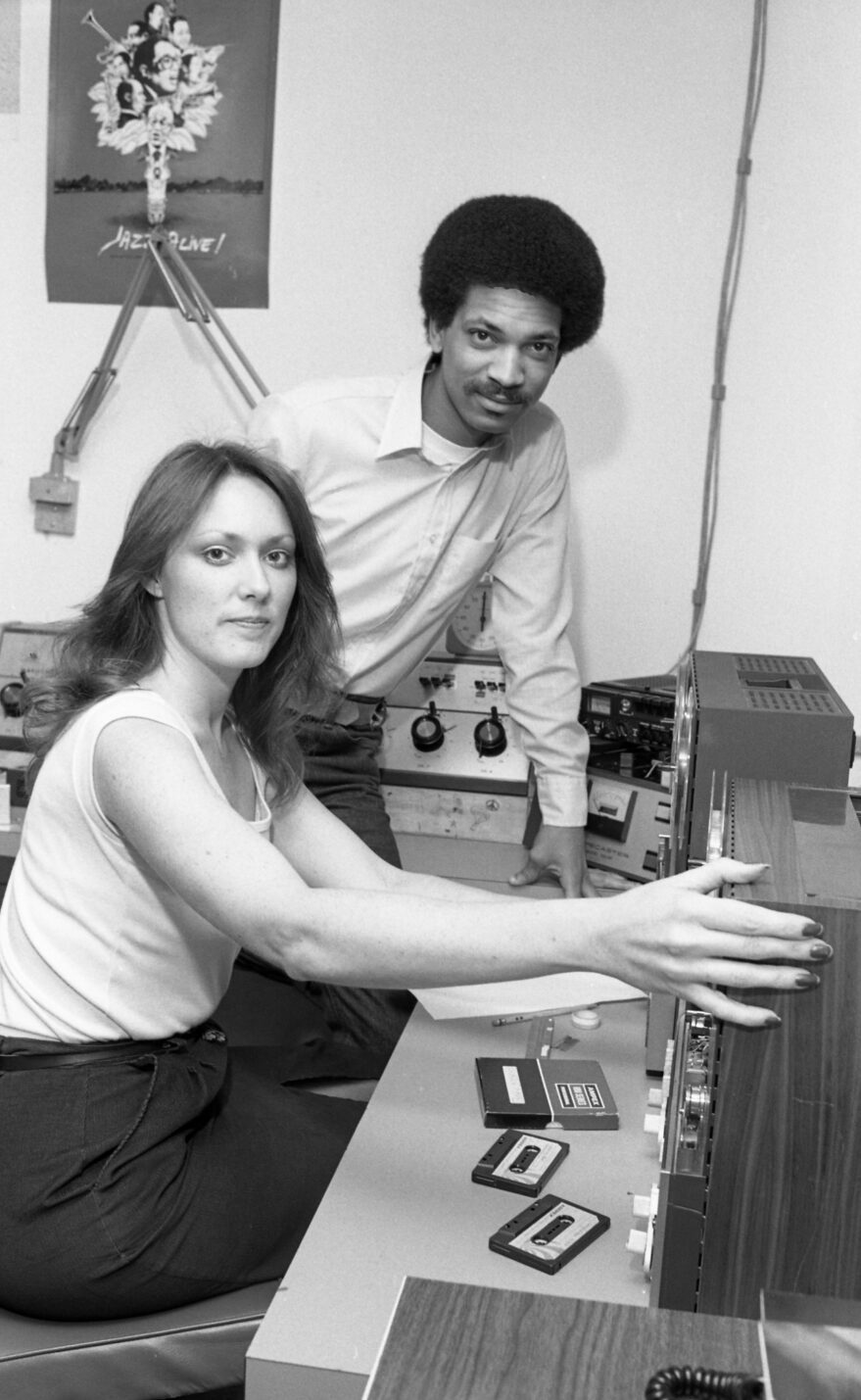 A black and white negative showing two people operating equipment at KETR.