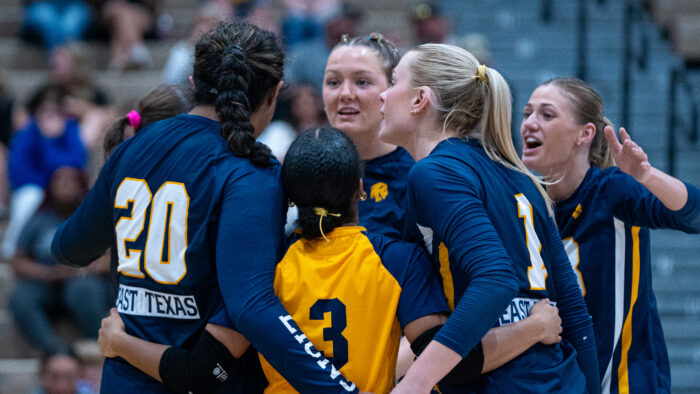 Volleyball players celebrating after earning a point in a match.