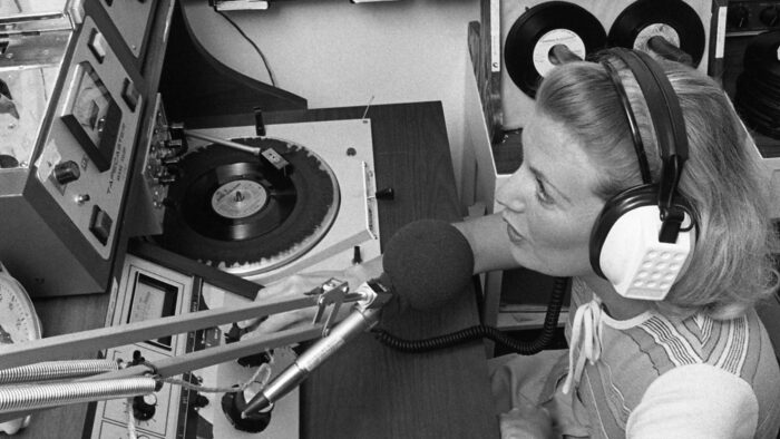 A black and white negative showing a student working with radio equipment for KETR-FM.