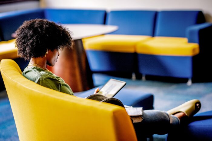 A person studying in a room on a college campus.