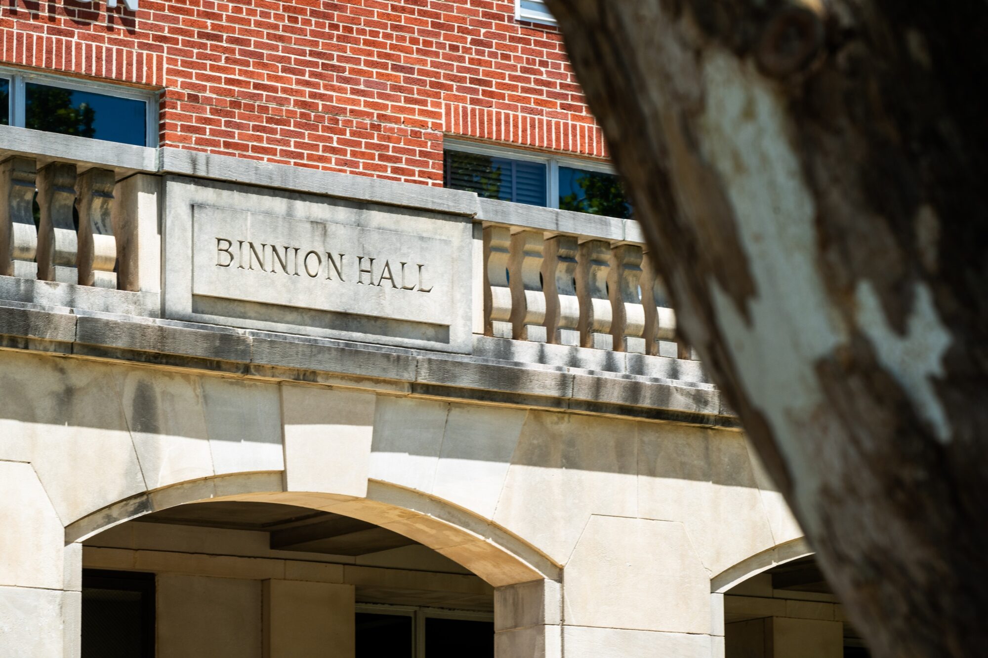 Concrete plaque on the second story of a red brick building reads "Binnion Hall" engraved in the concrete.