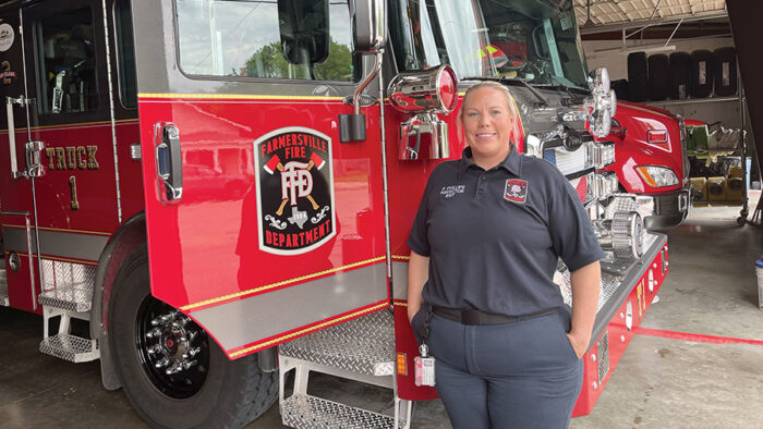 A firefighter standing next to a fire truck.
