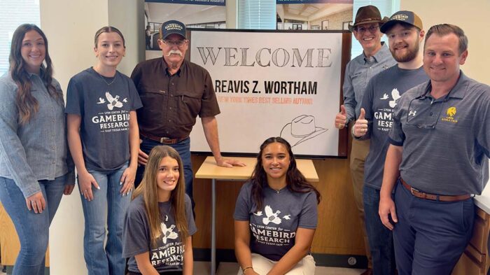 Students, faculty and Reavis Wortham standing around a welcome sign.