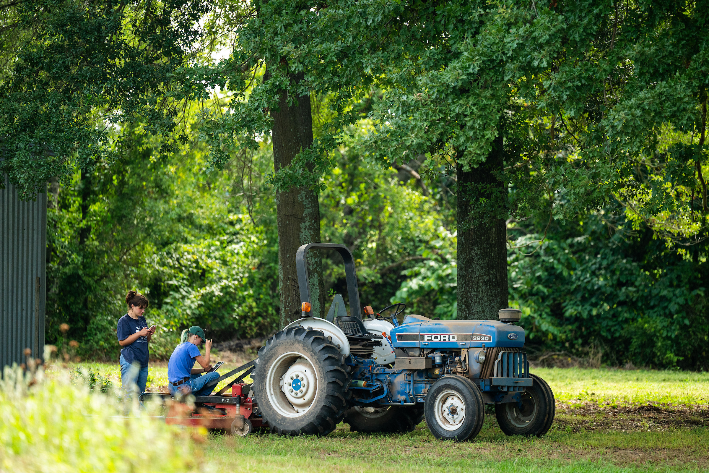 Twin Oaks Farm with Tractor and two people.