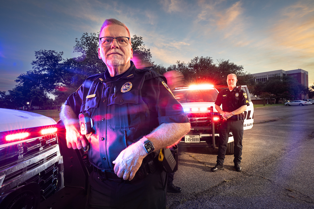 Police officers standing in front of squad vehicles