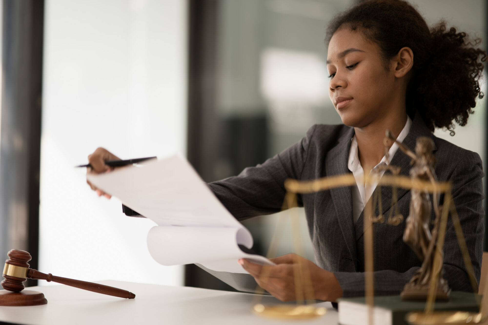 Female student studying notes. A gavel rests beside her on a table.