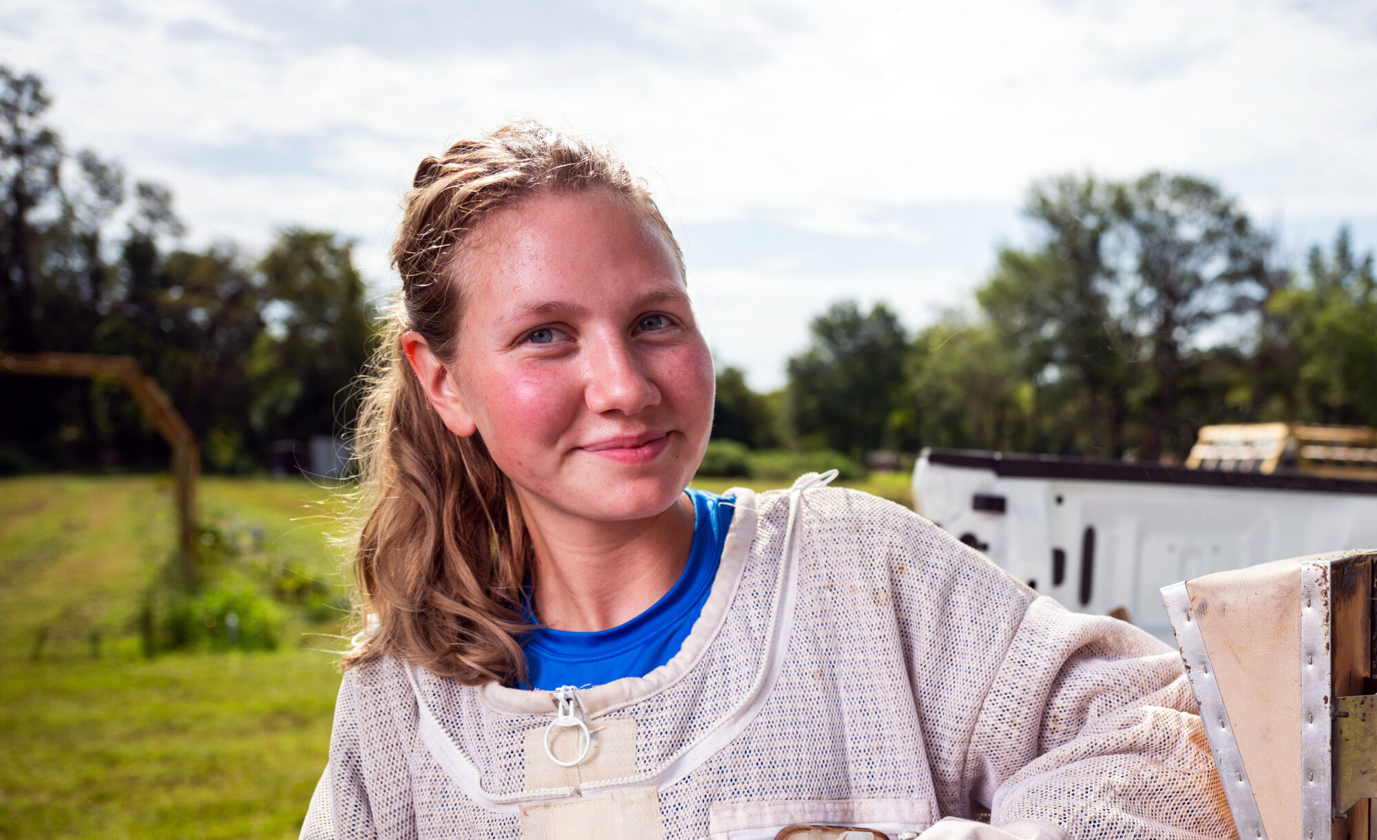 Female student wearing beekeeping protective gear.