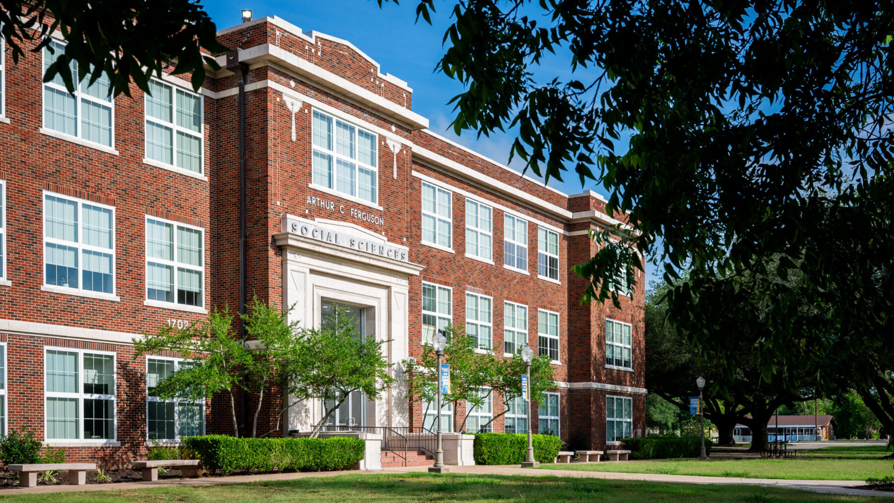 A photo of a three-story brick building on a college campus.