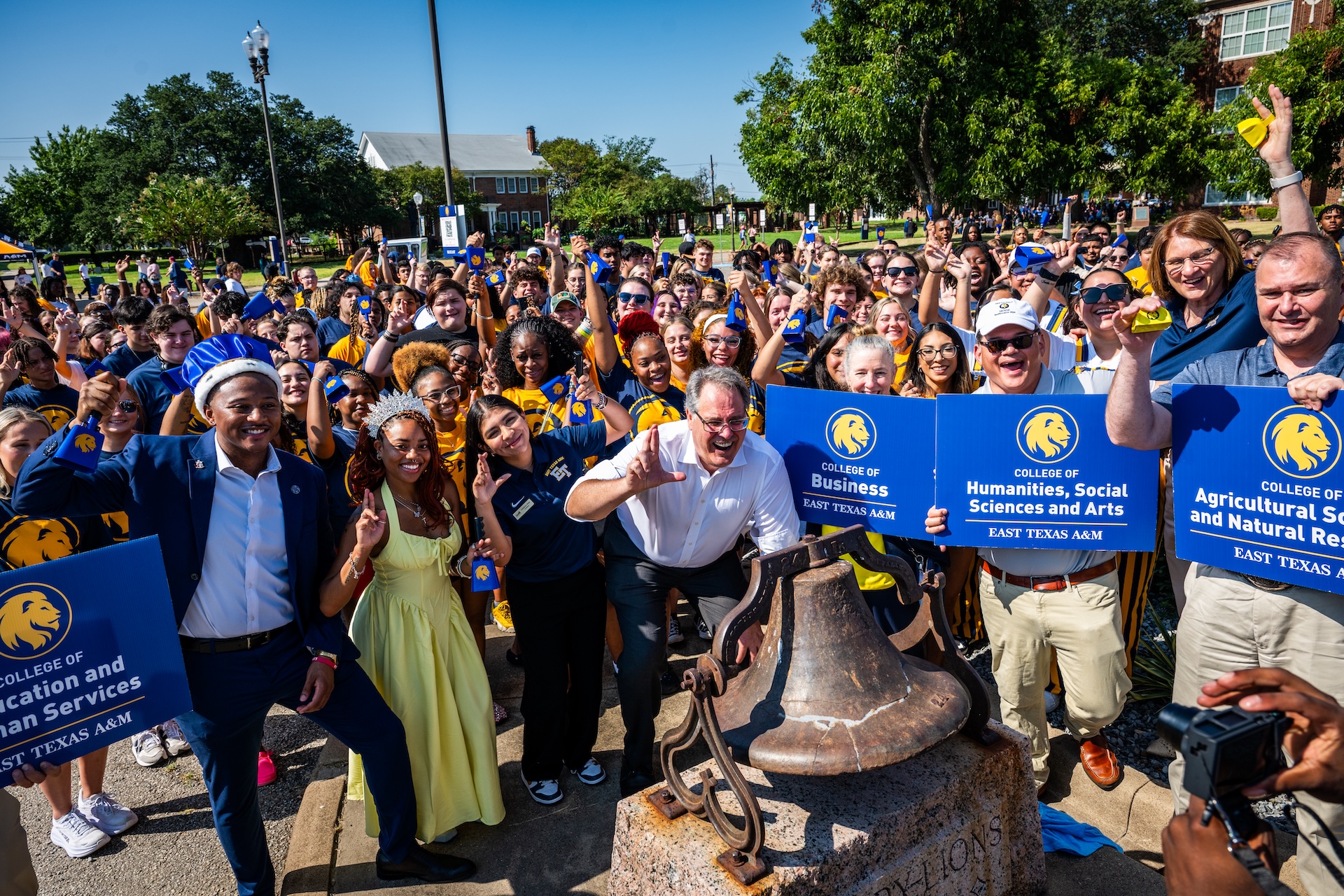 Students and faculty stand outside cheering