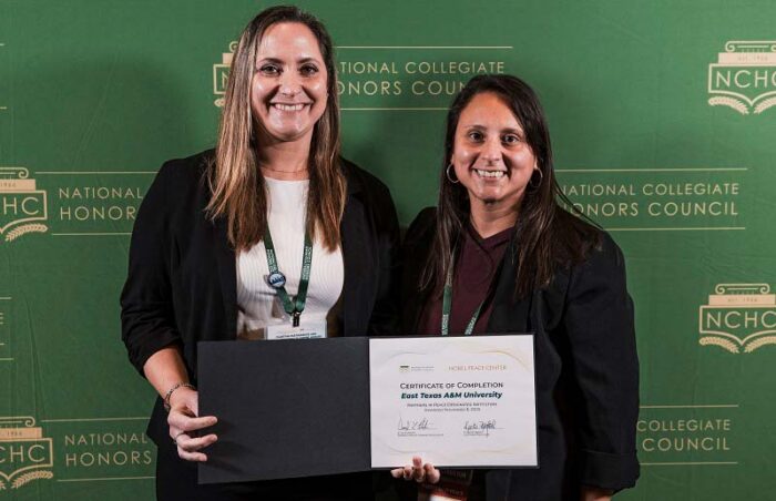 Two women stand holding a certificate of completion.