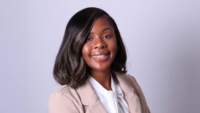 A woman smiling, looking forward.