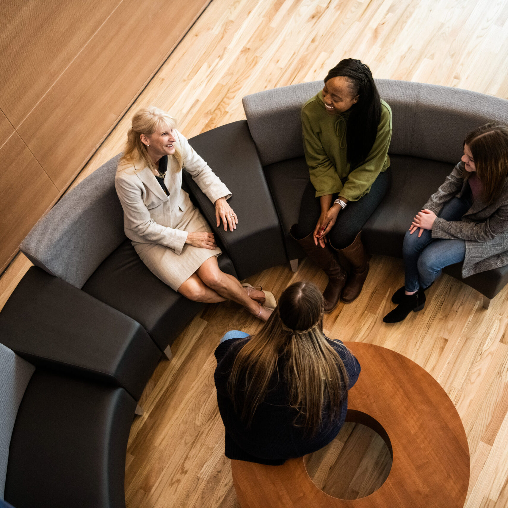 A teacher talking to a small group of student in the common area in the new health sciences building.