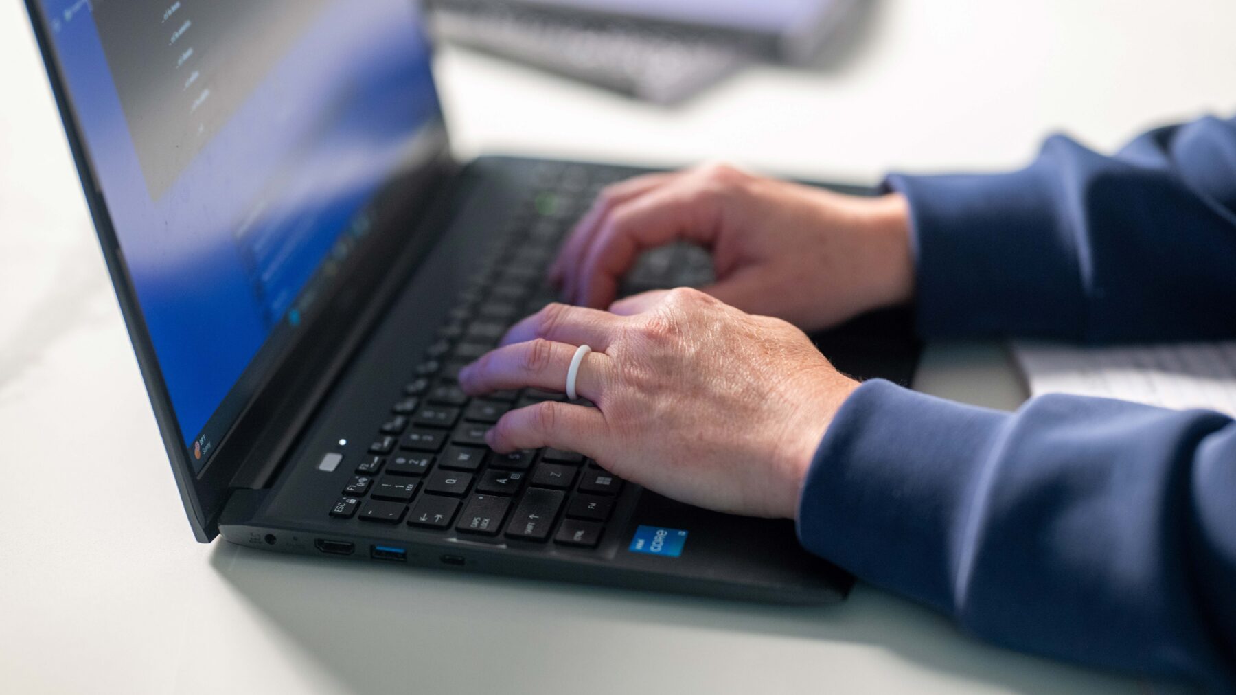 Hands typing on a laptop keyboard.