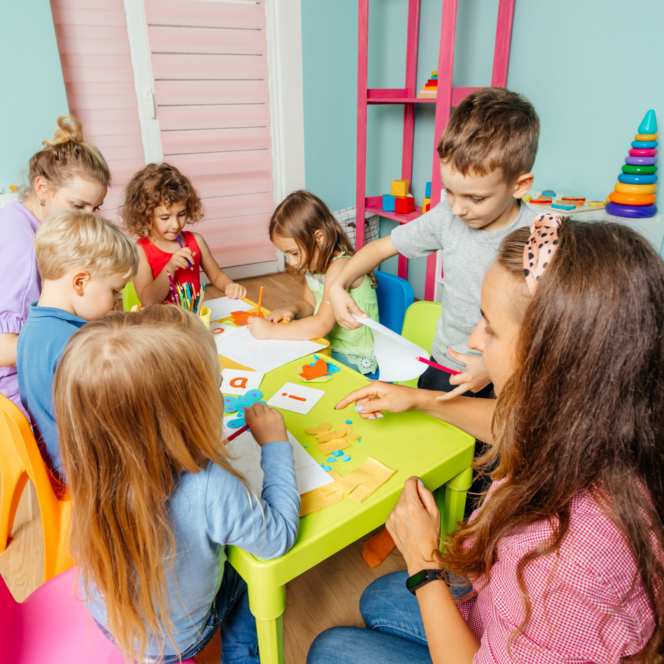A group of young students completing an art activity with the teacher.