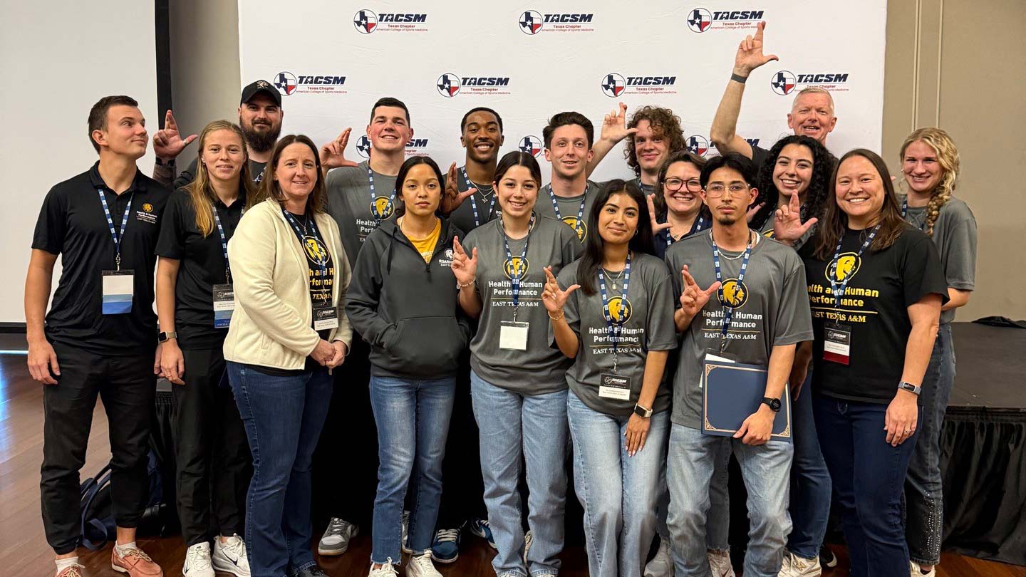 Seventeen people posing and smiling.